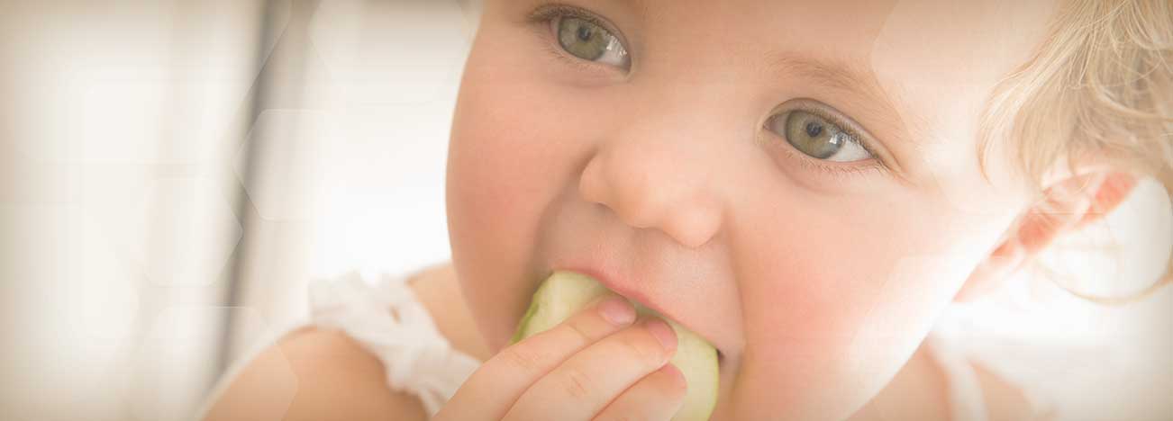 Niña sosteniendo fruta con su mano.