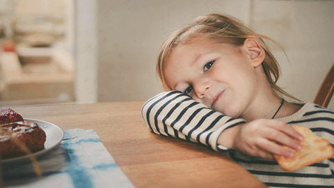 Niña sonriendo y sosteniendo un refrigerio.