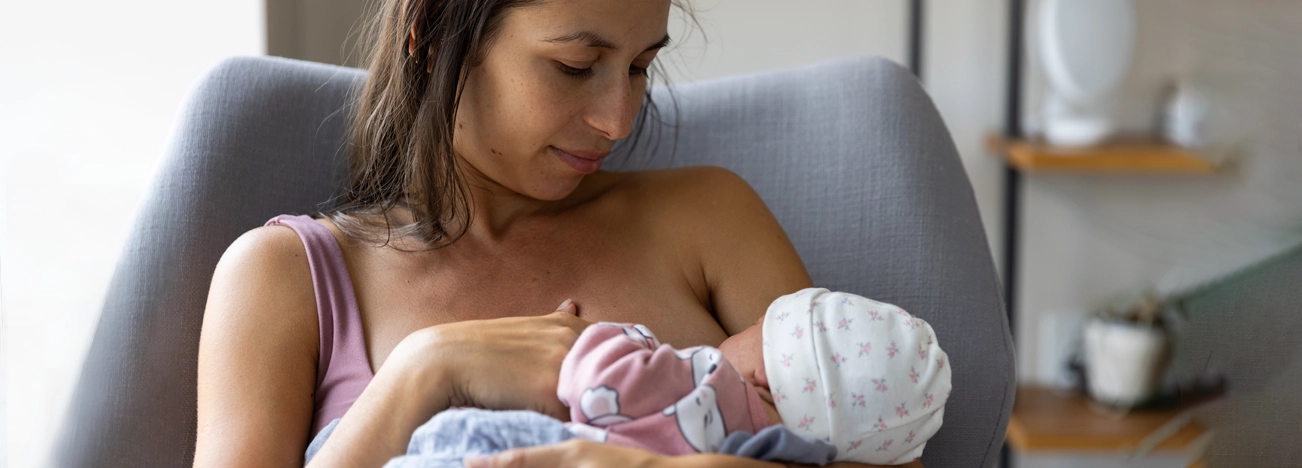 Mamá ofreciendo lactancia materna a bebé.