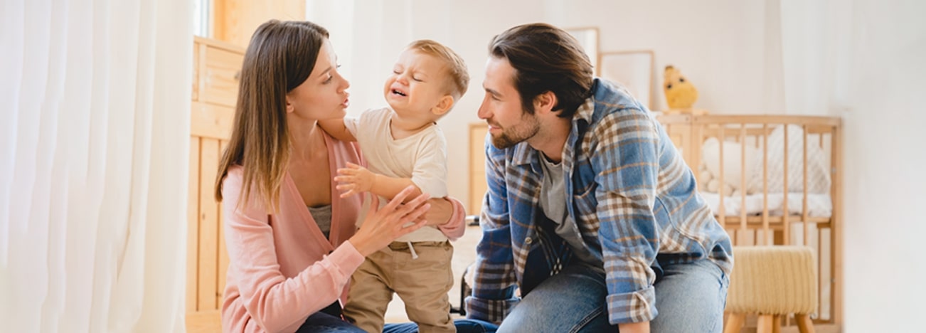 Mamá y papá viendo a su hijo como está haciendo berrinche.